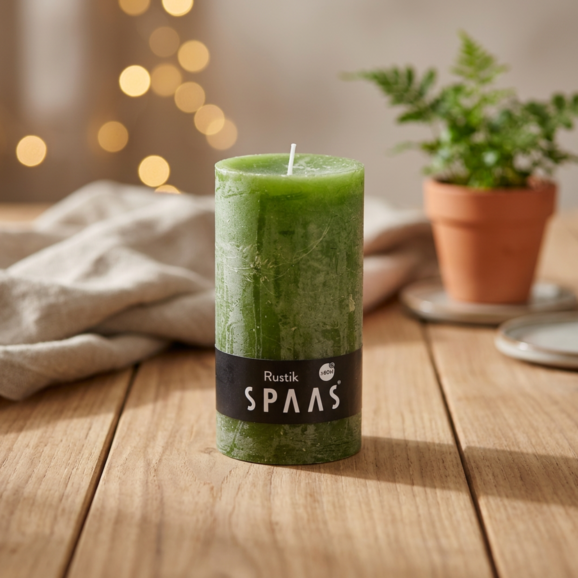 Grønt bloklys i cylinderform med væge og “SPAAS” etiket